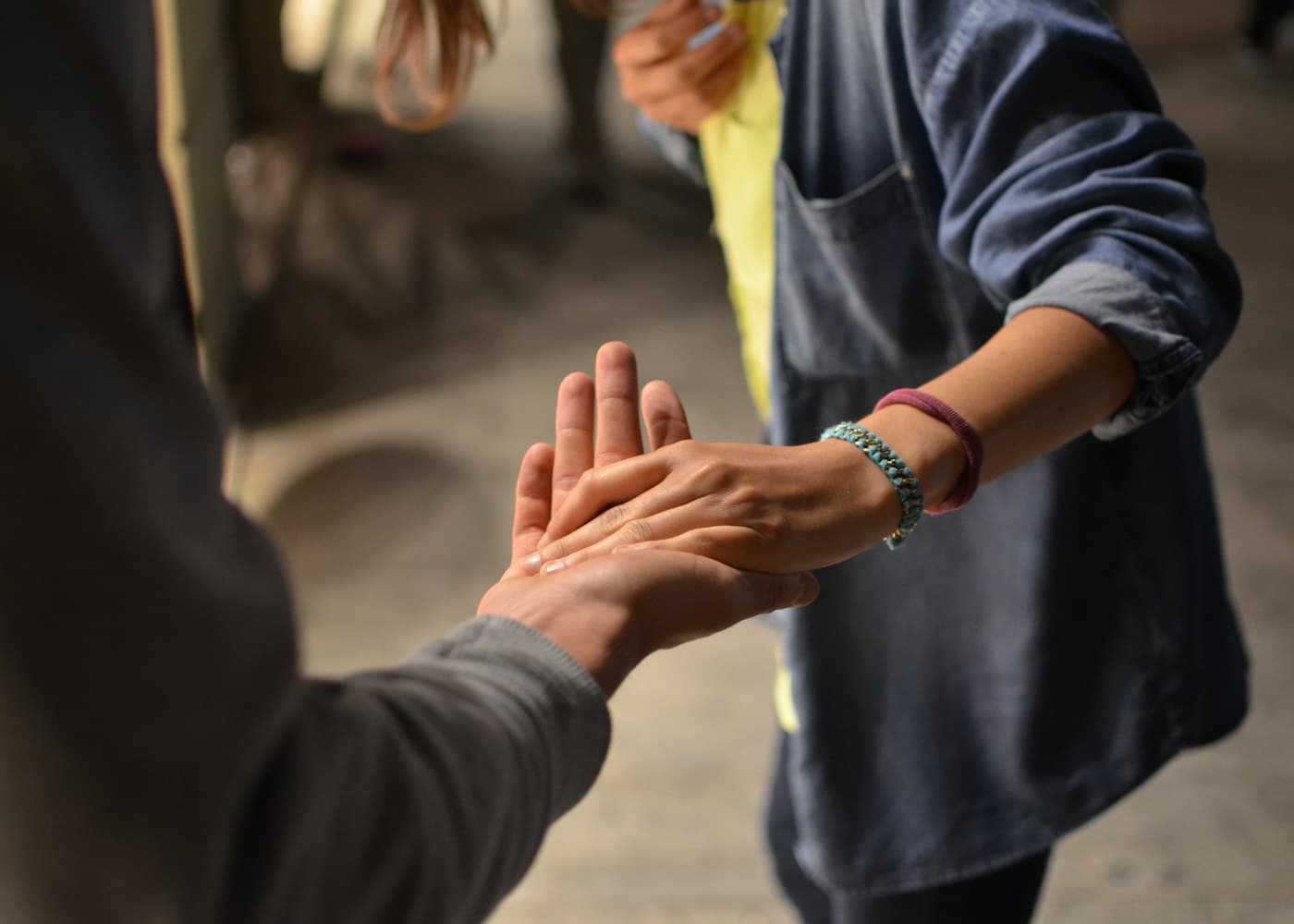 Two people gently holding hands.